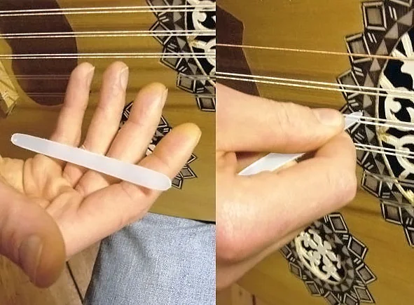 A plastic mızrap (plectrum) held in open palm and in playing position