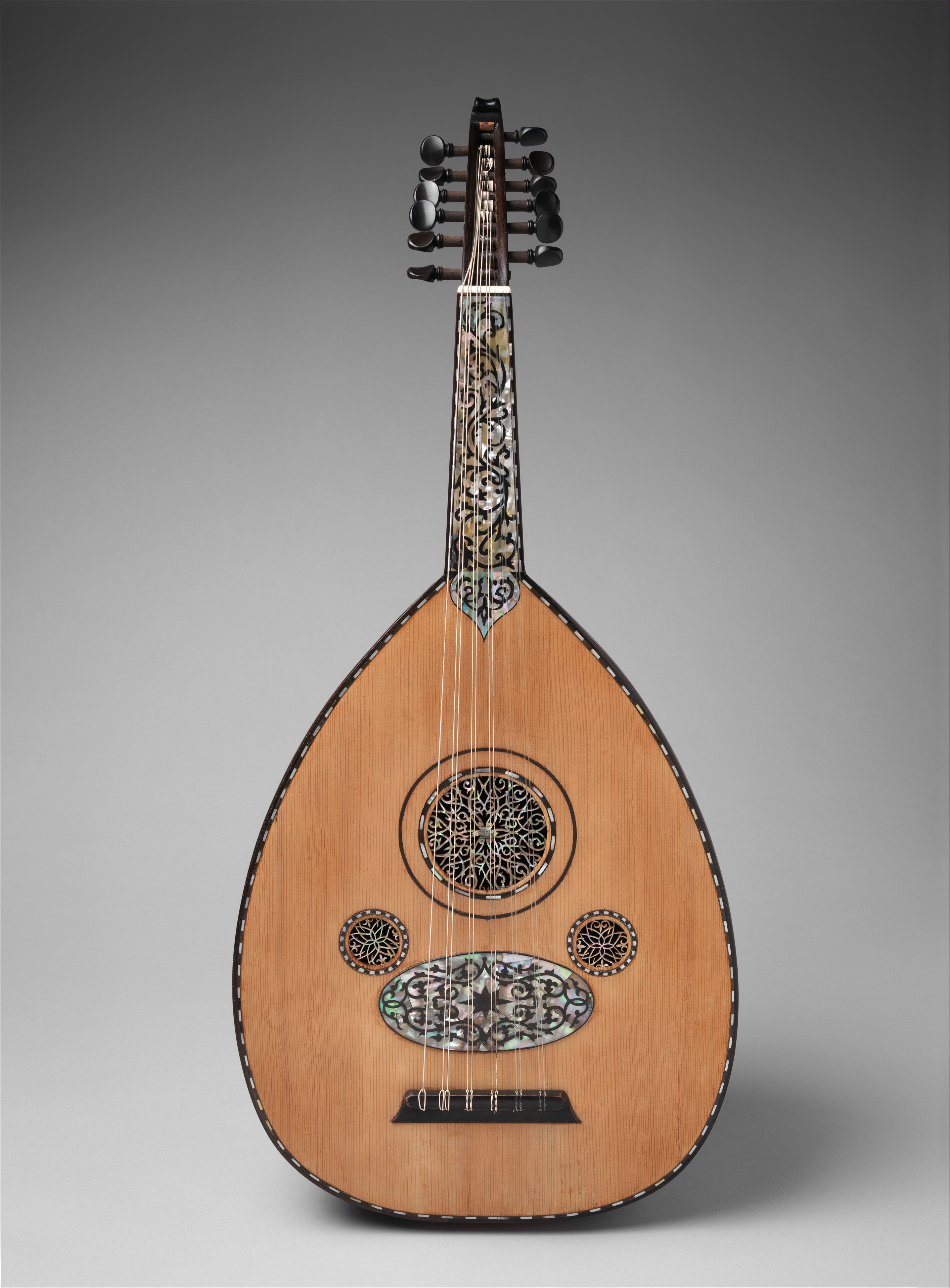 An ornamental oud with mother-of-pearl inlay and multiple rosettes